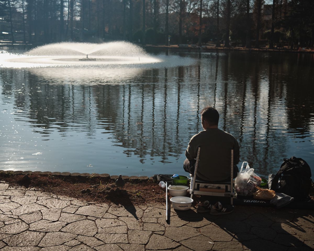 A man fishing with his pidgeon friend.